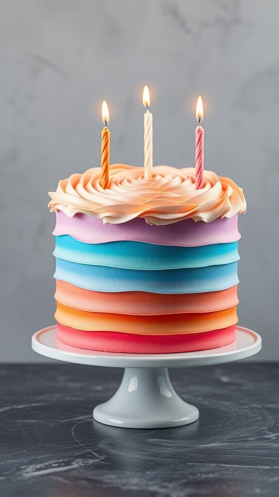 A beautifully decorated birthday cake with an ombre finish, featuring layers of pink, orange, blue, and topped with three lit candles.