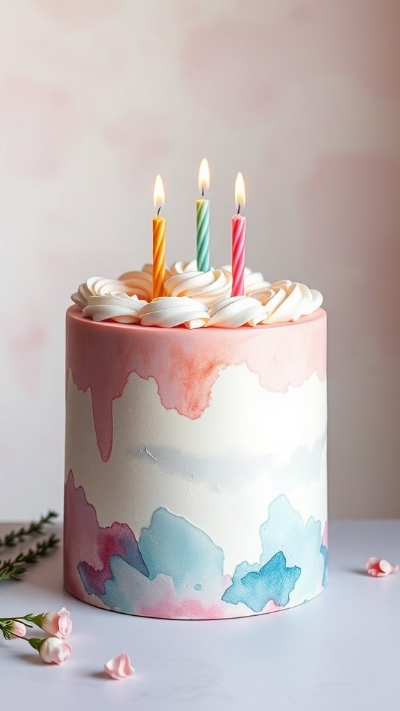 A birthday cake with a watercolor finish in pink and blue, topped with swirls of frosting and three lit candles.