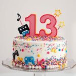 Colorful 13th birthday cake with teenage-themed decorations