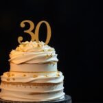 Elegant 30th birthday cake with gold decorations and candles