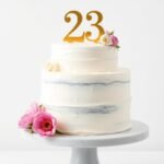 Elegant minimalist 23 birthday cake with gold accents and fresh flowers