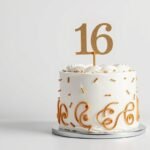 Elegant sweet sixteen birthday cake with gold decorations and sixteen candles
