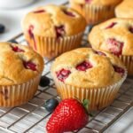 Strawberry Shortcake Blueberry Muffin: The Ultimate Berry Fusion Recipe Freshly baked strawberry shortcake blueberry muffins on a cooling rack with fresh berries scattered around