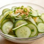 The Viral Cucumber Salad That's Breaking The Internet: Ultimate Recipe Guide Viral cucumber salad in a glass bowl with sesame seeds and green onions on top
