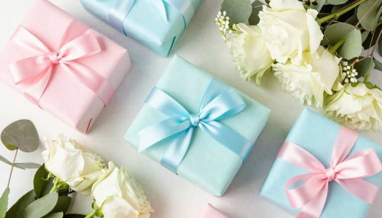 A beautifully arranged birthday gift display with wrapped presents in complementary colors, ribbons, and fresh flowers