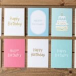 A collection of beautiful happy birthday cards displayed on a wooden table