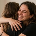 100+ Happy Birthday Wishes for a Friend: Find the Perfect Message Two friends embracing at a birthday celebration with soft lighting and genuine smiles