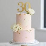 elegant 30th birthday cake for women with gold details and fresh flowers
