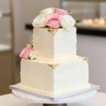 elegant square birthday cake with fresh flowers and cream frosting